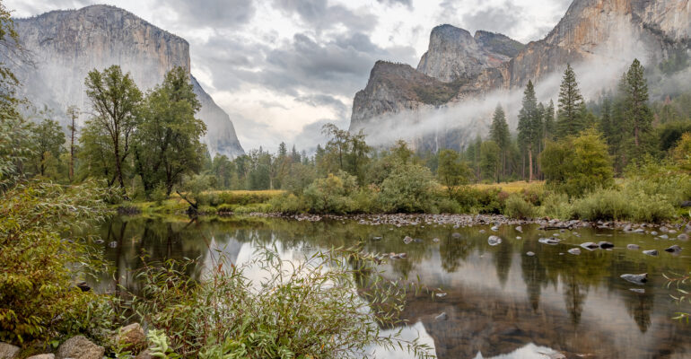 A dramatic scene in the Yosemite Valley as rain showers leave fog